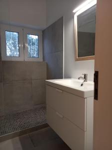 ein Badezimmer mit einem weißen Waschbecken und einer Dusche in der Unterkunft Tasi Ingrina in Vila do Bispo