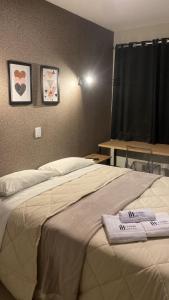 uma cama num quarto com duas toalhas em Living Hotel Morumbi em São Paulo