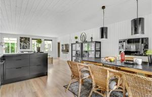 an open kitchen with a black counter and chairs at Nice Home In Ebeltoft With Wifi in Ebeltoft