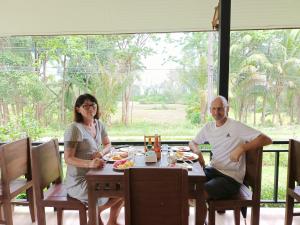 a man and woman sitting at a table eating food at The mantra resort in Ban Tha Rua