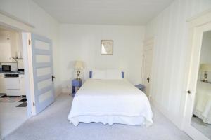 a white bedroom with a white bed and a desk at Brown & Hawkins Historical Apartments in Seward