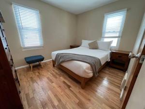 a small bedroom with a bed and two windows at Snug, neighborly home perfect for your small group in Billings