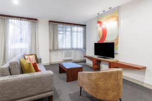 uma sala de estar com um sofá e uma televisão em CityLife Wellington em Wellington