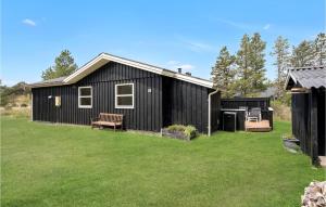 una casa negra con un patio delante en Cozy Home In Blvand With Wifi en Blåvand