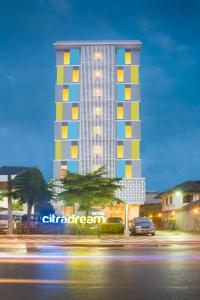 een hoog gebouw met een auto ervoor geparkeerd bij Hotel Citradream Semarang in Semarang