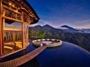a resort with a pool and mountains in the background at Elevate Bali in Munduk