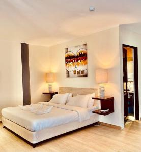 een slaapkamer met een groot wit bed en 2 lampen bij Alona Northland Resort in Panglao