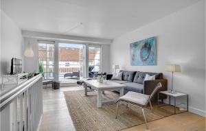 uma sala de estar com um sofá e uma mesa em Cozy Apartment In Nykbing Sj With Outdoor Swimming Pool em Rørvig
