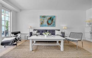 een woonkamer met een witte tafel en een bank bij Cozy Apartment In Nykbing Sj With Outdoor Swimming Pool in Rørvig