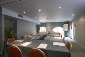 a long room with a long table and chairs at Hotel & Spa Radiana in La Léchère +42 photos