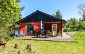 une maison rouge avec une terrasse dotée de chaises et d'une table dans l'établissement 3 Bedroom Lovely Home In Rnne, à Rønne