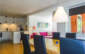 a dining room and living room with a table and chairs at 3 Bedroom Lovely Home In Rnne in Rønne