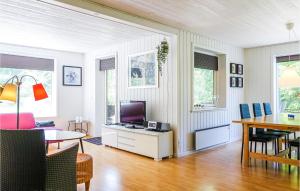 a living room with a television and a dining table at 3 Bedroom Lovely Home In Rnne in Rønne