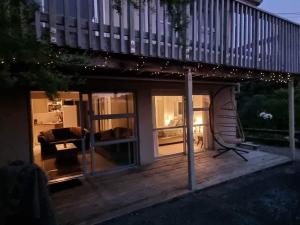 a house with a deck at night with lights at HarbourView Hotel in Raglan