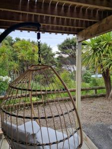 a bird cage hanging from a pergola at HarbourView Hotel in Raglan