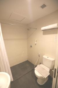 a bathroom with a white toilet and a shower at Hotel Citradream Semarang in Semarang