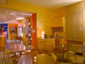un restaurante con mesas y sillas y una cocina en Albergo Ristorante Corsini, en Pavullo nel Frignano