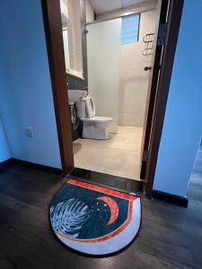 een badkamer met een tapijt op de vloer naast een toilet bij NEW 6pax 3BR Sunrise view 100m Attractive Places Kea Farm in Cameron Highlands