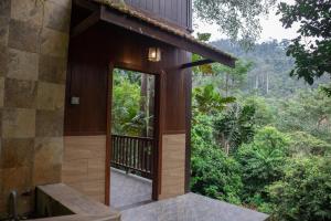 an open door to a house with a view of the forest at Deserenity in Seremban