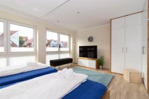 two beds in a room with a tv and a bedroom at Marina 20-D in Cuxhaven