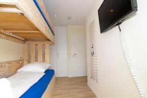 a bedroom with a bed and a flat screen tv at Marina 20-D in Cuxhaven
