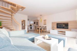 ein Wohnzimmer mit blauen Sofas und einem Tisch in der Unterkunft Marina 22-B in Cuxhaven
