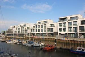 un grupo de barcos atracados en el agua frente a un edificio en Marina 22-B en Cuxhaven