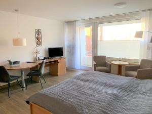 a bedroom with a bed and a desk and a table at Trafalgar 231 in Döse