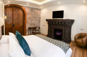 a bedroom with a bed with a fireplace and a television at Wanderlot - Hotel Plaza Central in Riobamba