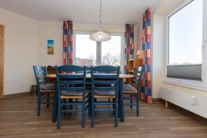 een eetkamer met blauwe stoelen en een tafel bij Kurpark-Residenz 123 in Döse