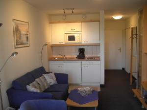 sala de estar con sofá y cocina en Kurpark-Residenz 111, en Döse