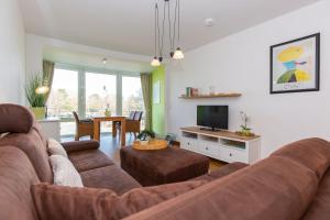 sala de estar con sofá y TV en Kurpark-Residenz 141 en Döse