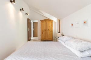 a bedroom with a white bed and a wooden cabinet at Apartment Nadia in Lokva Rogoznica +19 photos