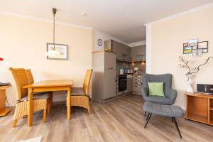 a kitchen and dining room with a table and chairs at Trafalgar 123 in Döse
