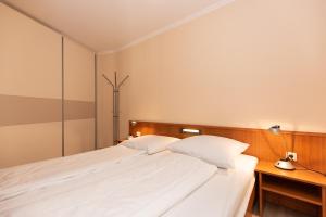 a bedroom with a large white bed and a lamp at Trafalgar 123 in Döse +13 photos