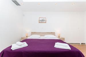 1 dormitorio con 1 cama morada y 2 toallas en Villa Ana, en Umljanović 22 fotos más
