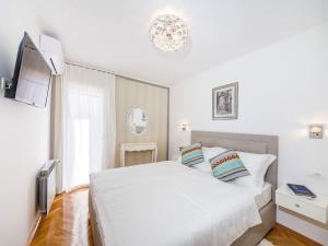 ein Schlafzimmer mit einem weißen Bett und einem Fernseher in der Unterkunft Villa Beauty Luxury Vodice in Vodice + 29 Fotos