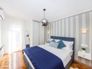 ein Schlafzimmer mit einem blauen und weißen Bett mit blauen Kissen in der Unterkunft Villa Beauty Luxury Vodice in Vodice