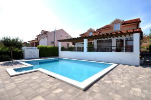 a swimming pool in front of a house at Villa Divine in Vodice