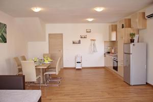 a kitchen and dining room with a table and a white refrigerator at Villa Divine in Vodice