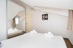 a white bedroom with a mirror and a bed at Villa Divine in Vodice +47 photos