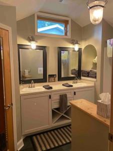 a bathroom with two sinks and two mirrors at Dartt's Park Flat in Owatonna