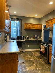 a kitchen with wooden cabinets and a stove top oven at Dartt's Park Flat in Owatonna