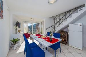 comedor con mesa y sillas azules en Villa MarAnte en Mravnica
