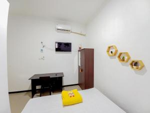 Cette chambre comprend un lit et un bureau avec un cœur sur le mur. dans l'établissement Homestay Bahari near Wisata Bahari Tlocor Sidoarjo Mitra RedDoorz, à Bangil
