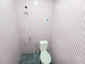 La salle de bains est pourvue d'une douche et de toilettes. dans l'établissement Homestay Bahari near Wisata Bahari Tlocor Sidoarjo Mitra RedDoorz, à Bangil