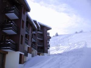 ヴァルモレルにあるAppartement Valmorel, 2 pièces, 4 personnes - FR-1-356-285の山の横に雪が積もった建物