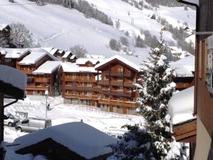a ski lodge in the snow with a tree at Appartement Valmorel, 3 pièces, 4 personnes - FR-1-356-324 in Valmorel