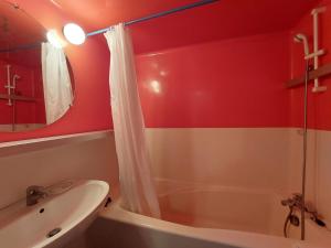 łazienka z białą wanną i umywalką w obiekcie Appartement cosy 6 pers, accès direct pistes et commerces, balcon sud, Arc 1800 Villards - FR-1-411-860 w mieście Bourg-Saint-Maurice