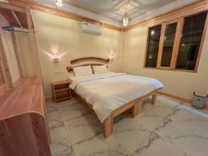 a bedroom with a bed with a wooden head board at Black Pearl Himandhoo in Himandhoo 